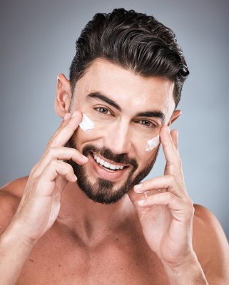 man with neat beard and grooming techniques applying topical sunscreen to protect his face